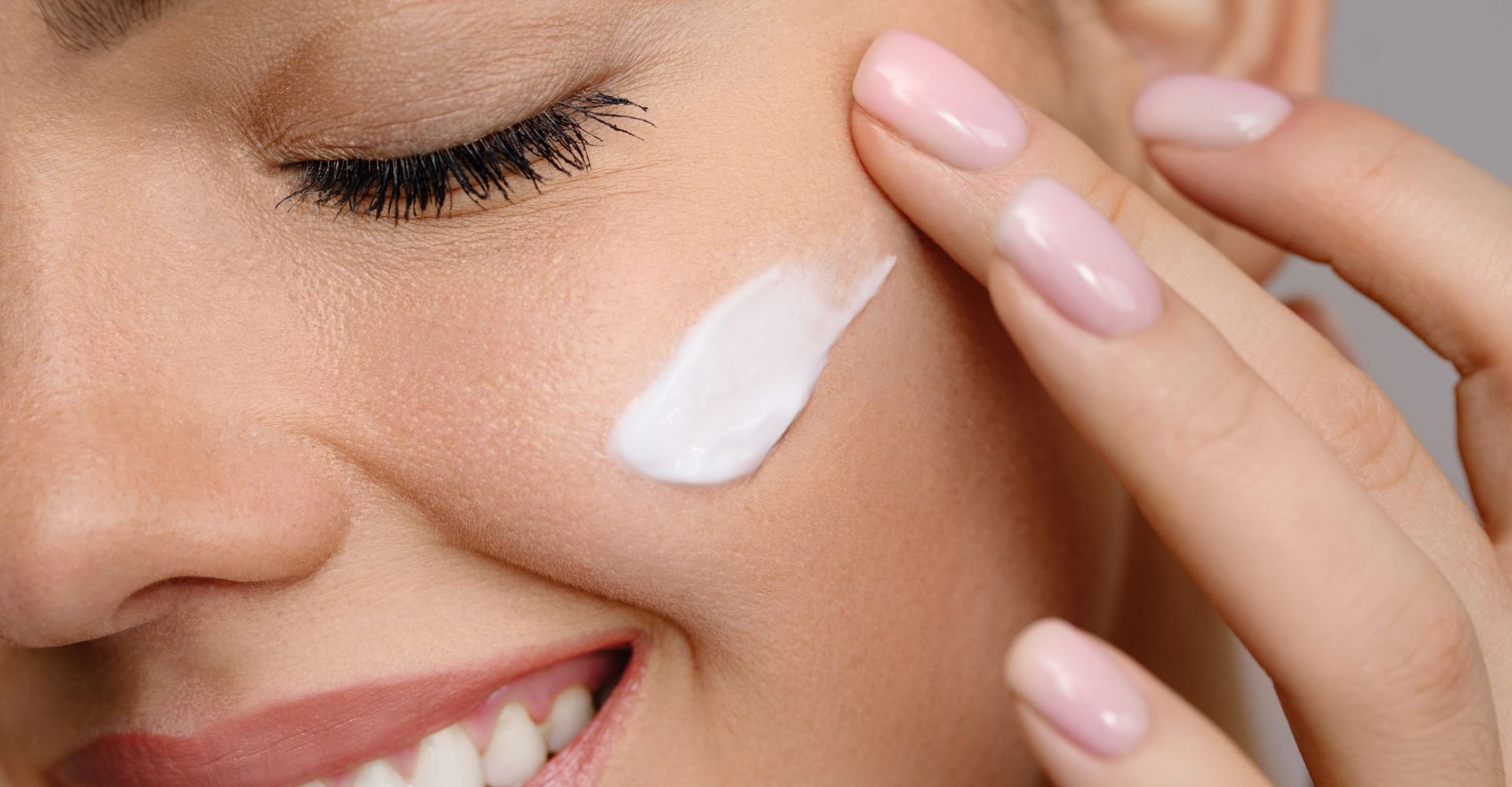 Mulher caucasiana aplica creme de rosa mosqueta no rosto para hidratar