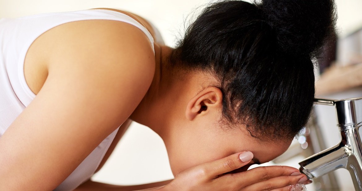 Jovem negra utiliza um sabonete líquido para espinhas no rosto