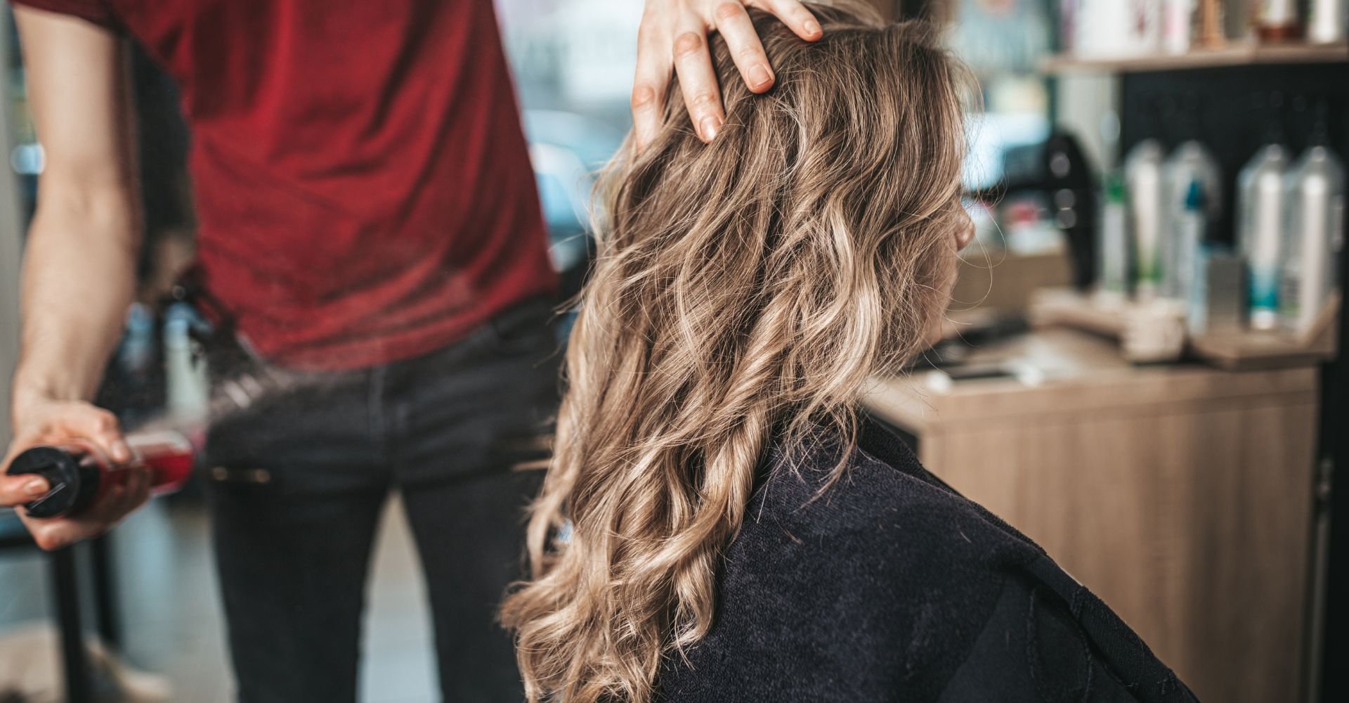 Profissional realiza corte de cabelo para encorpar e dar volume aos fios finos e ralos de sua cliente no salão de beleza.