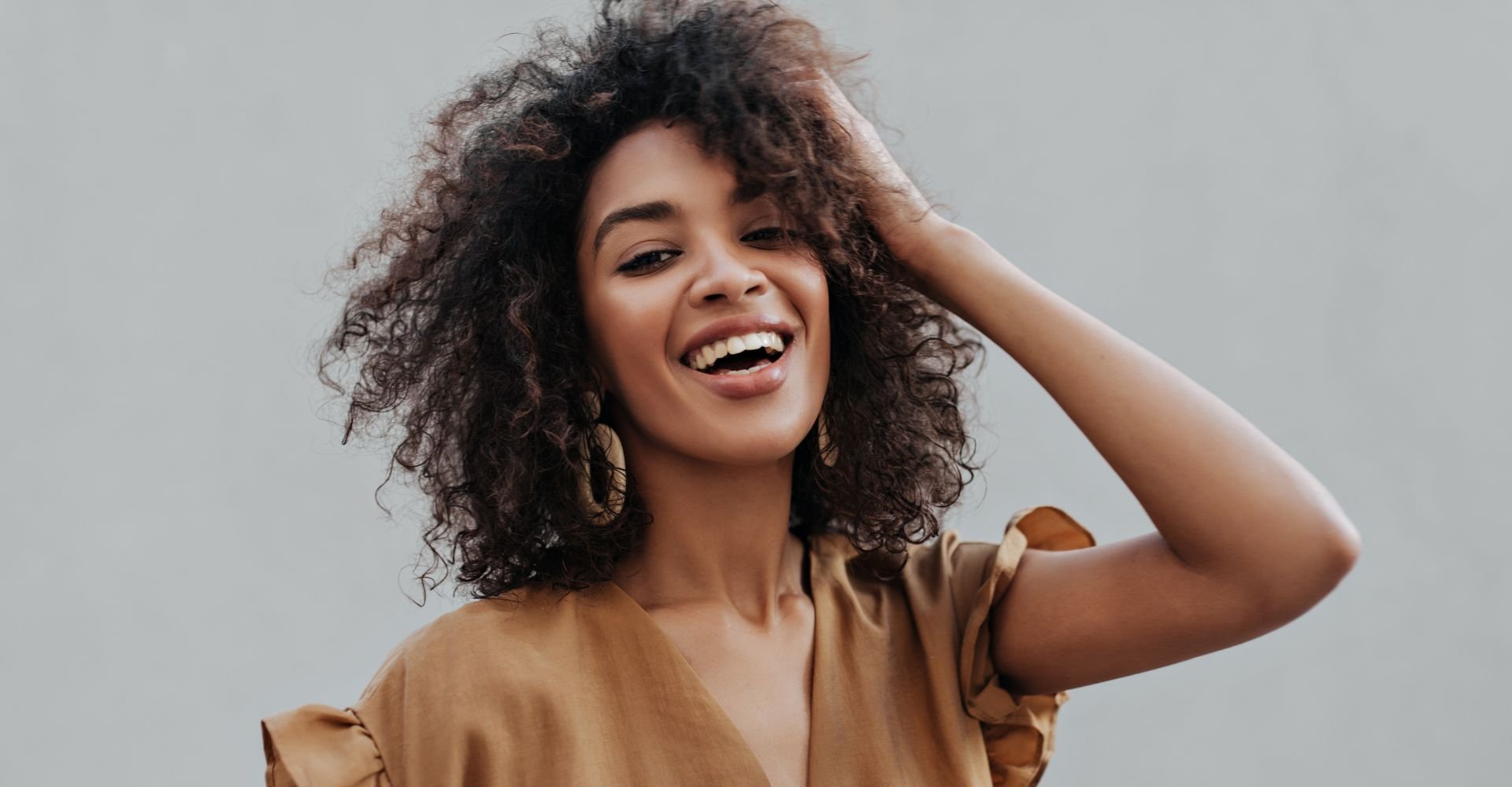 Mulher com tinta de cabelo castanho escuro em seu cabelo cacheado.