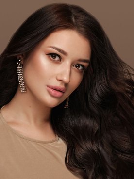 Menina com cabelo aos ventos e cabelo preto longo.