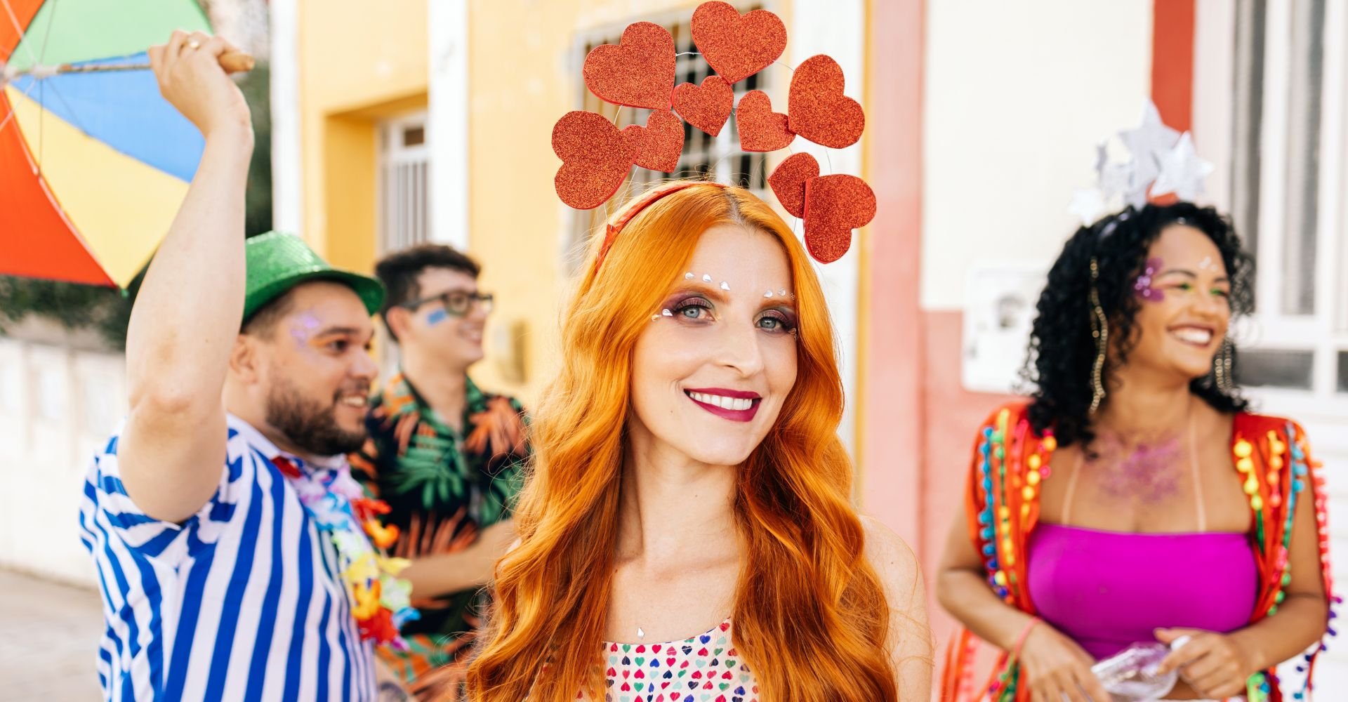 Mulher com cabelo ruivo e enfeite tiara de coração durante o carnaval