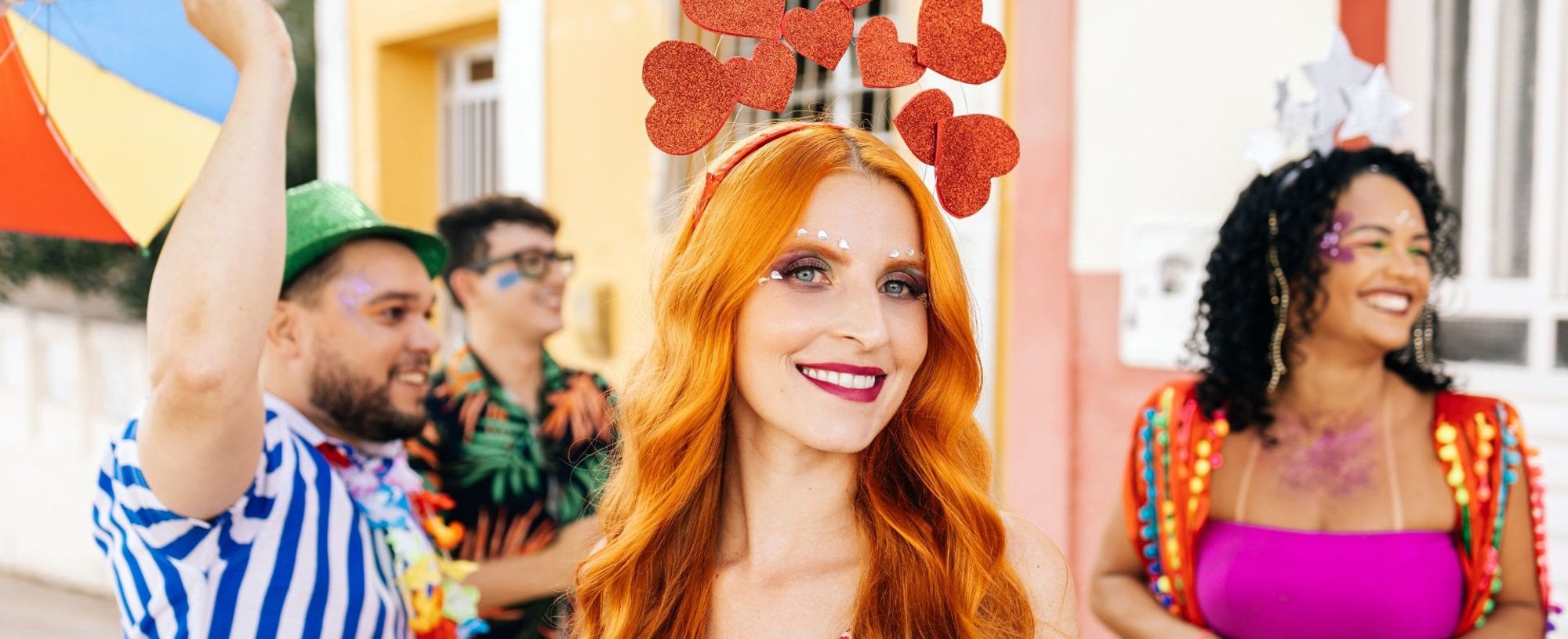 Mulher com cabelo ruivo e enfeite tiara de coração durante o carnaval