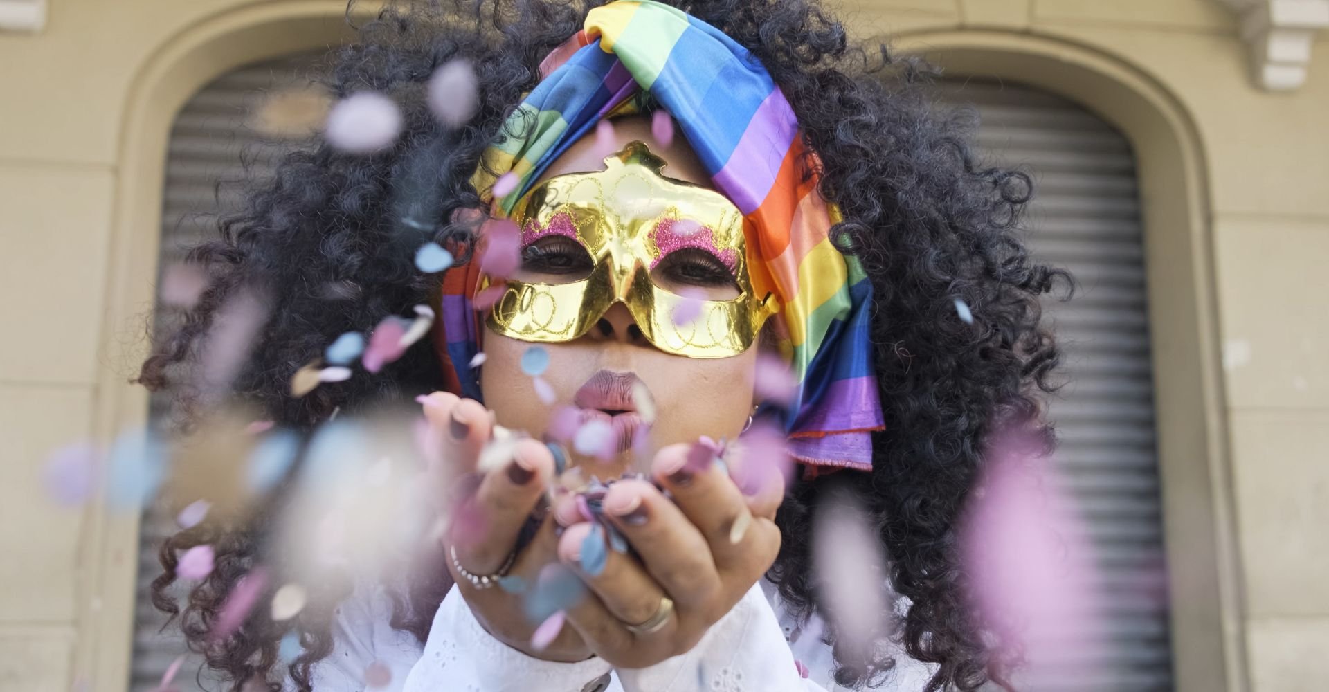 Mulher mascarada, soprando confeitos de carnaval