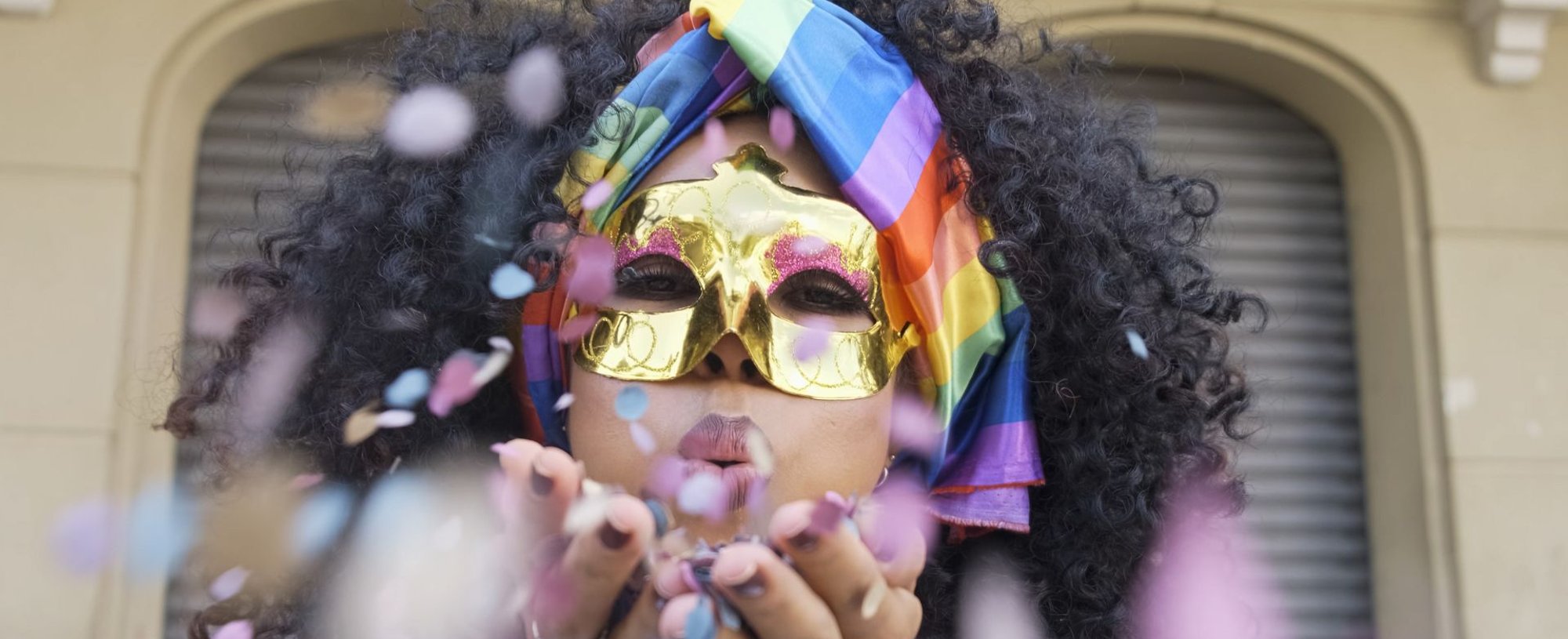 Mulher mascarada, soprando confeitos de carnaval