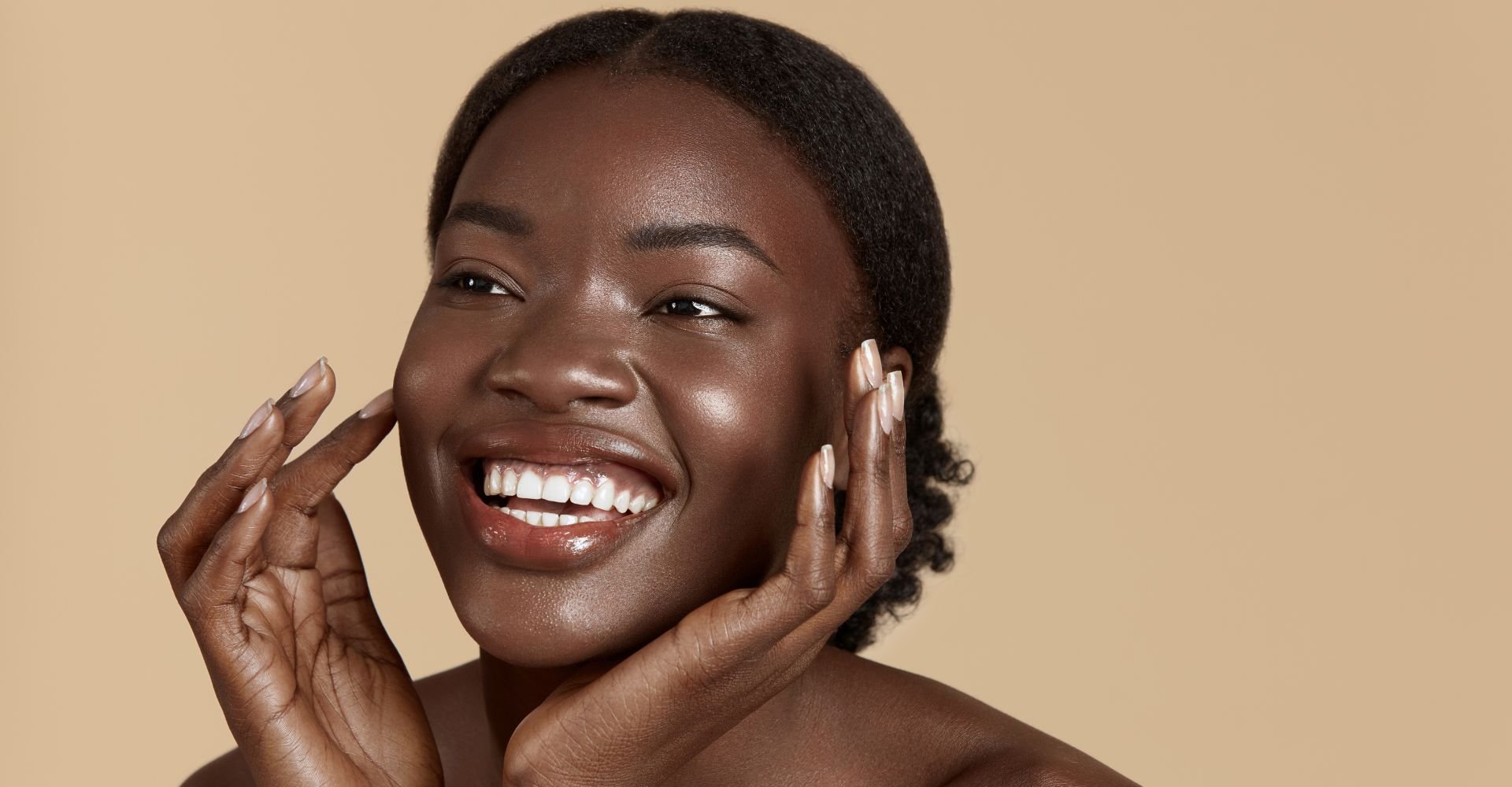 Mulher sorrindo enquanto aplica vitaminas para o rosto.
