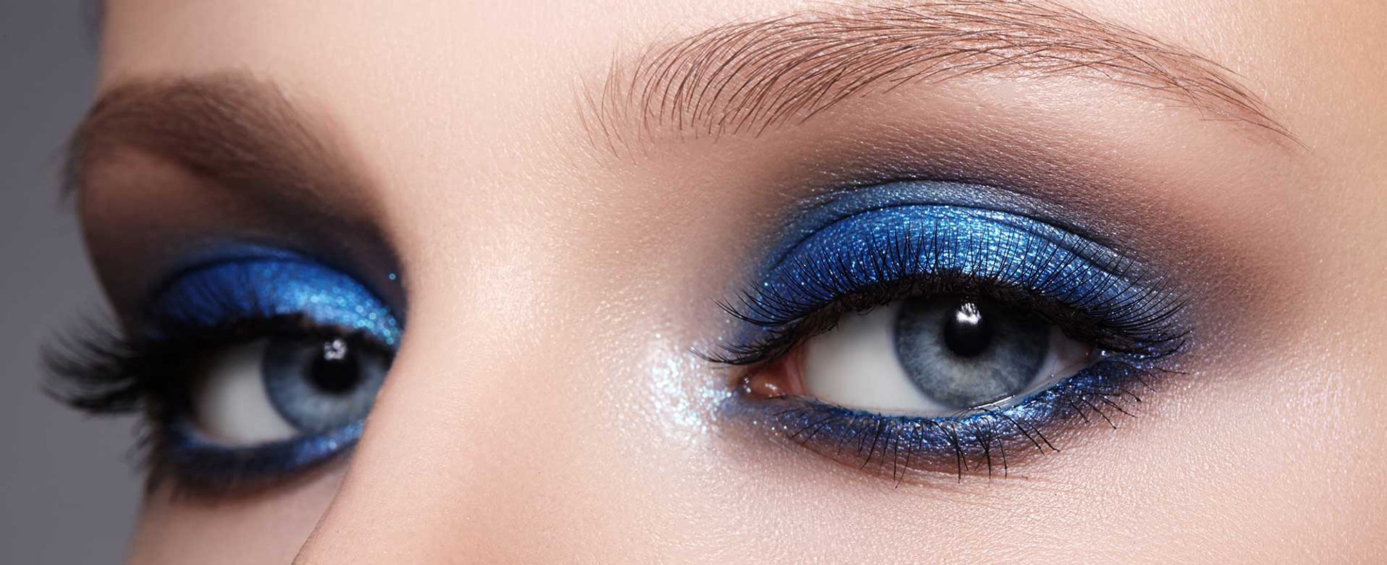 Imagem mostrando os olhos de uma mulher com maquiagem azul