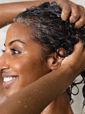 Modelo negra tomando banho e lavando os cabelos