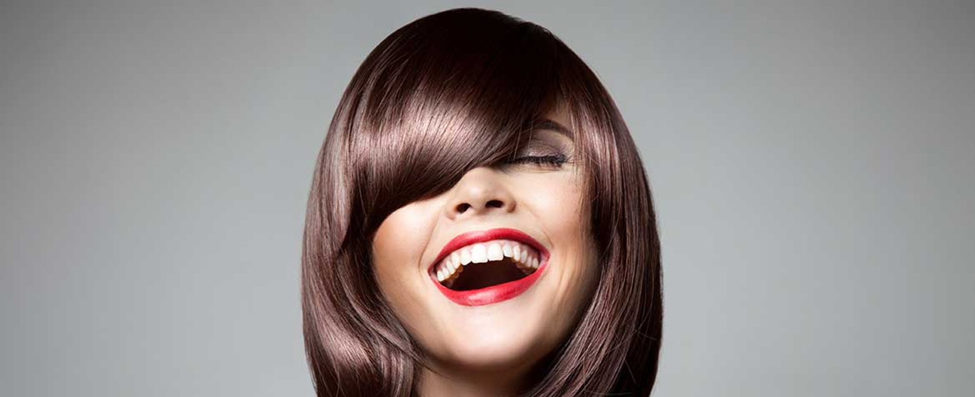 Modelo com cabelo curto e franja sorrindo