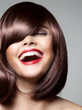 Modelo com cabelo curto e franja sorrindo