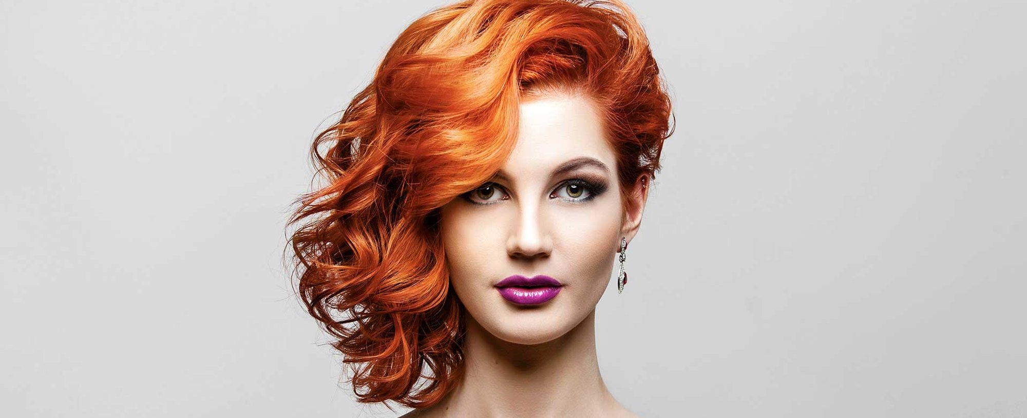 Modelo ruiva com o cabelo todo pro lado esquerdo