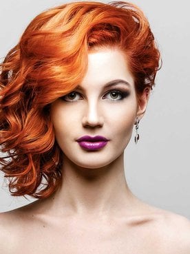 Modelo ruiva com o cabelo todo pro lado esquerdo