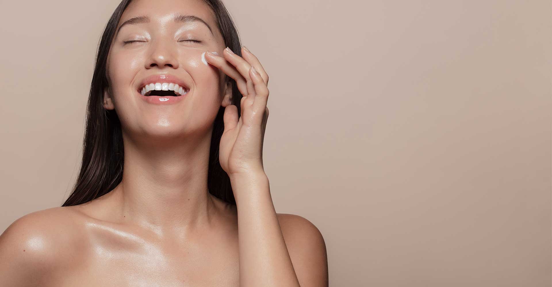 Modelo Asiatica Sorrindo Passando Produto Em Sua Pele