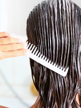 Mulher passando pente em seu cabelo