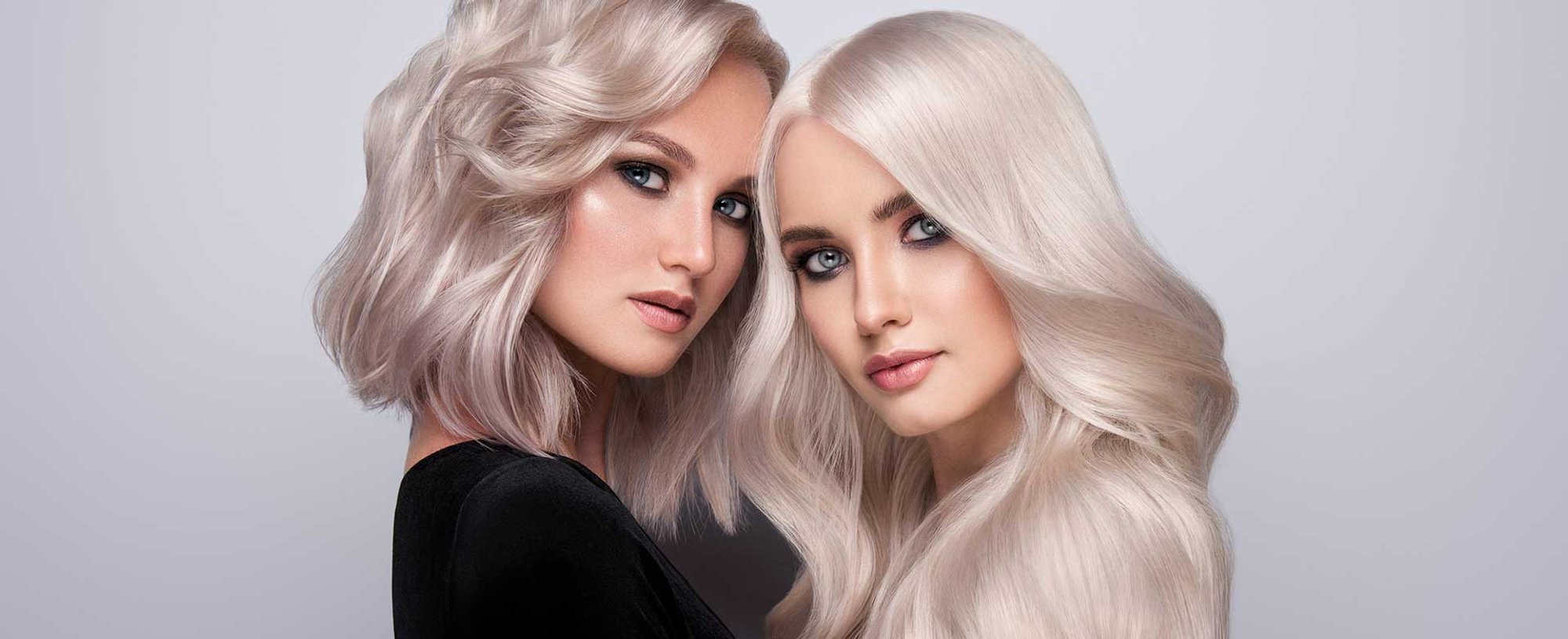 Dupla de modelos com cabelos platinados uma com cabelo mais curto que a outra