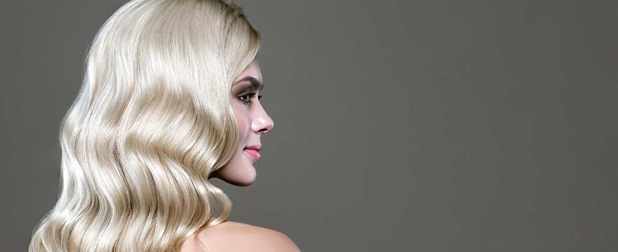 Modelo com cabelo platinado de costas levemente ondulado nas pontas