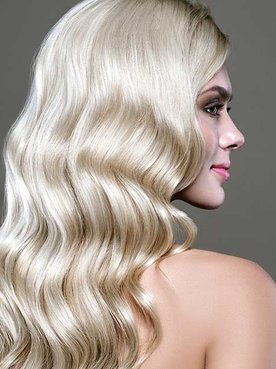 Modelo com cabelo platinado de costas levemente ondulado nas pontas