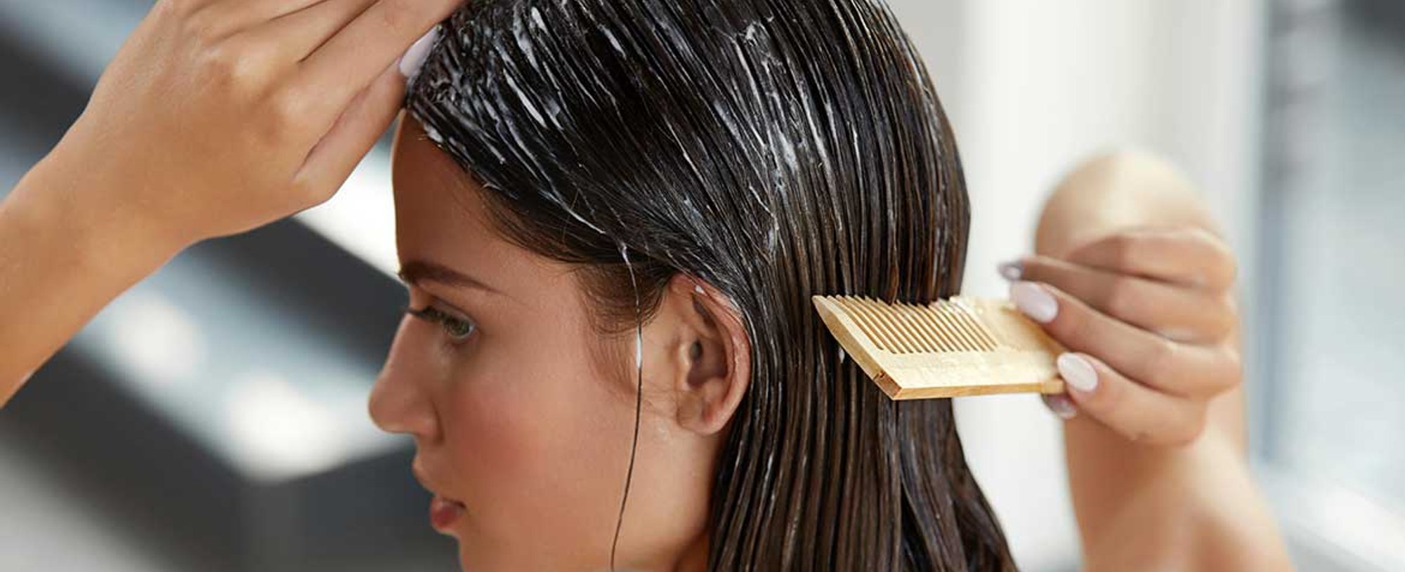 Modelo passando pente em seu cabelo com produto