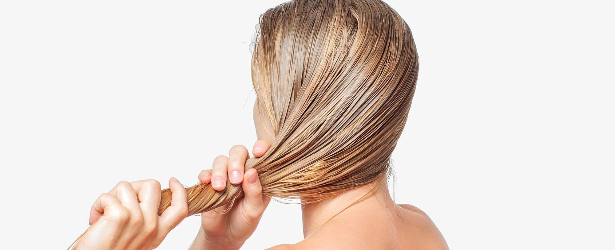 Modelo loira de costas arrumando seu cabelo
