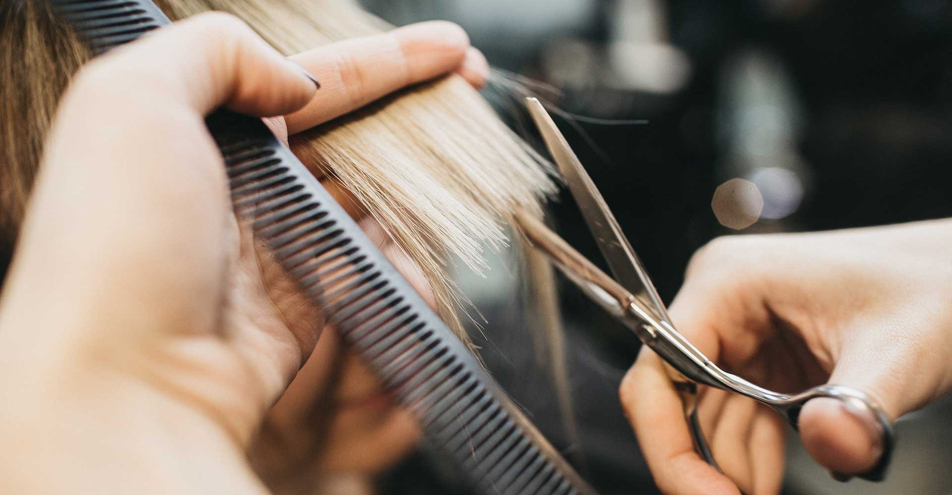 Profissional Cortando Os Cabelos Loiros De Uma Mulher