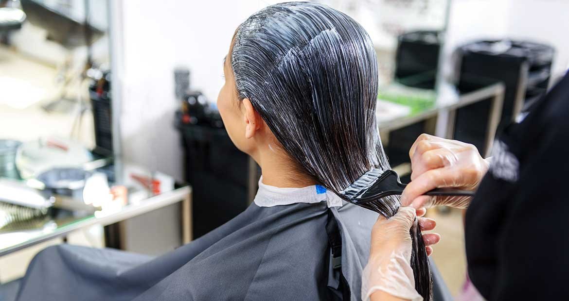 Profissional Passando Produto Em Cabelos Pretos Lisos De Uma Mulher