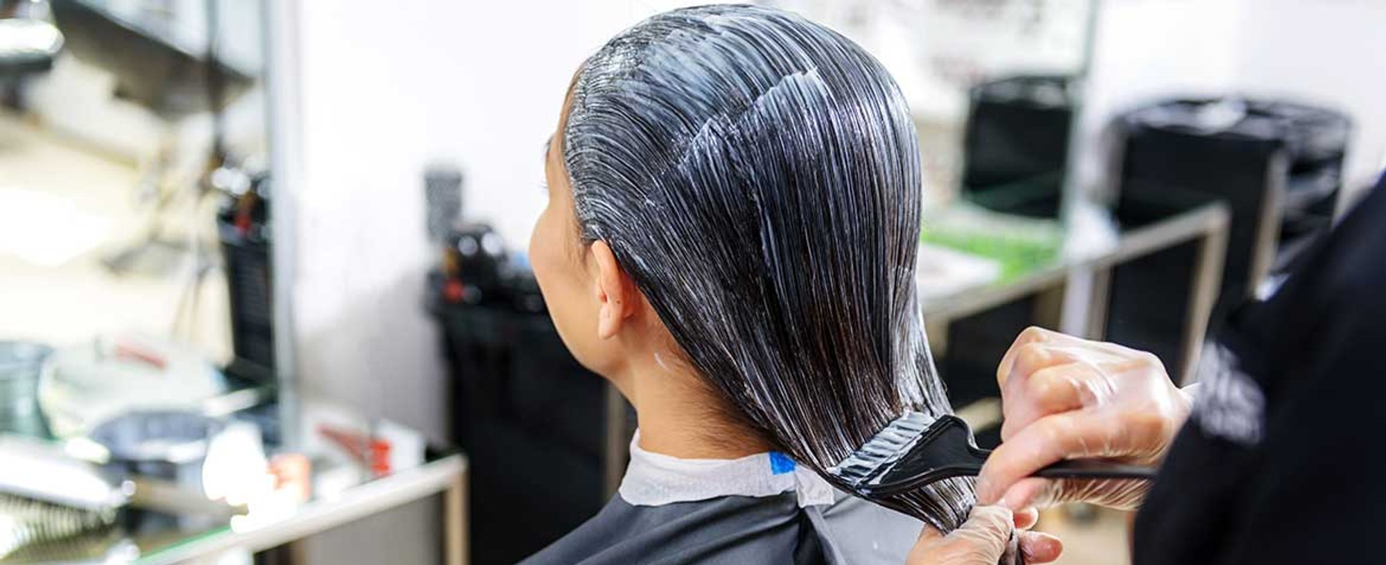 Profissional Passando Produto Em Cabelos Pretos Lisos De Uma Mulher