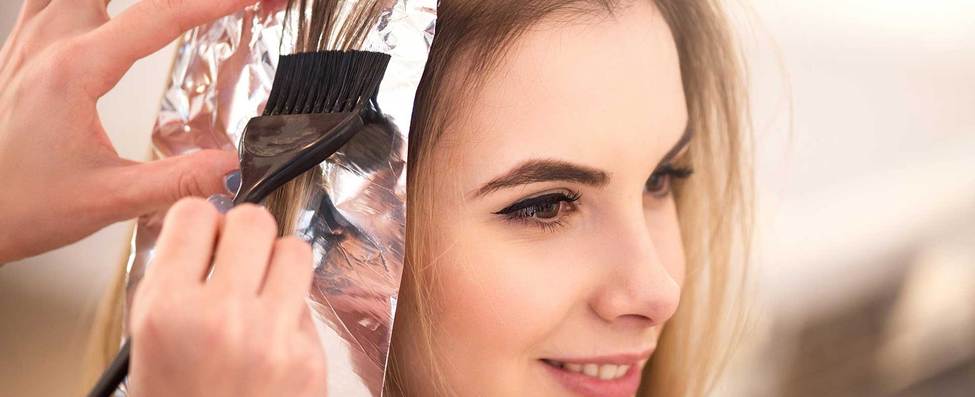 Profissional Passando Produto No Cabelo De Uma Mulher