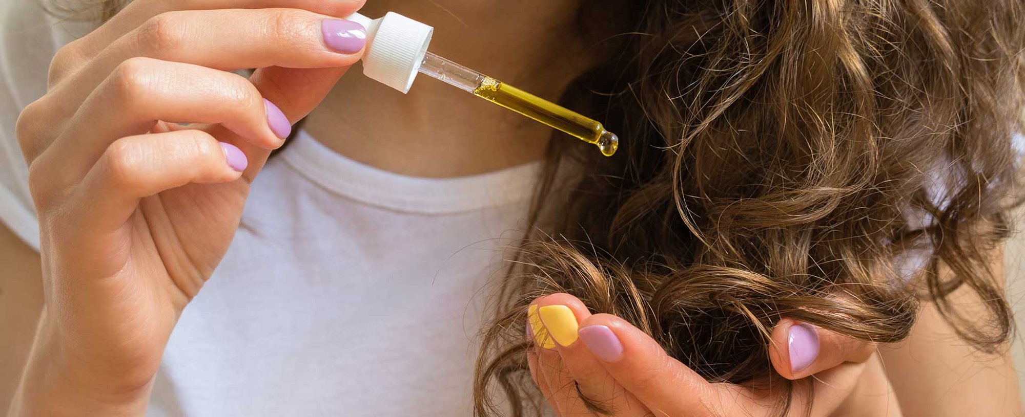 Modelo Com Cabelo Cacheado Castanho Passando Produto Em Seu Cabelo