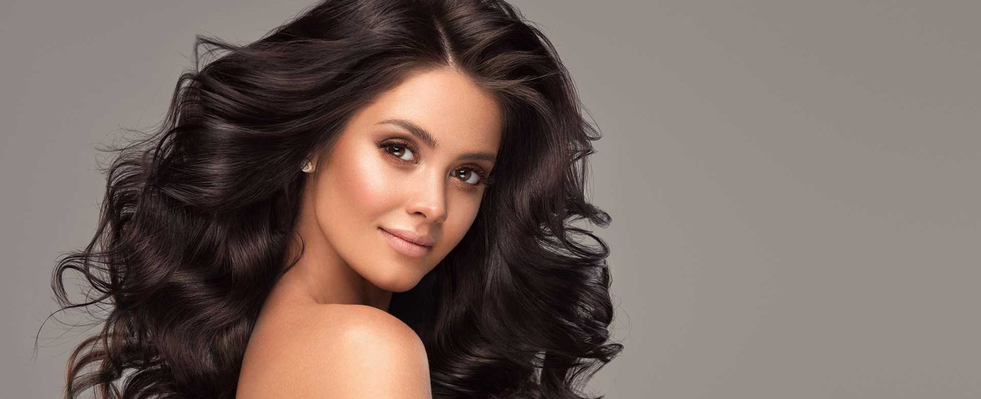 Modelo com cabelo ondulado preto volumoso