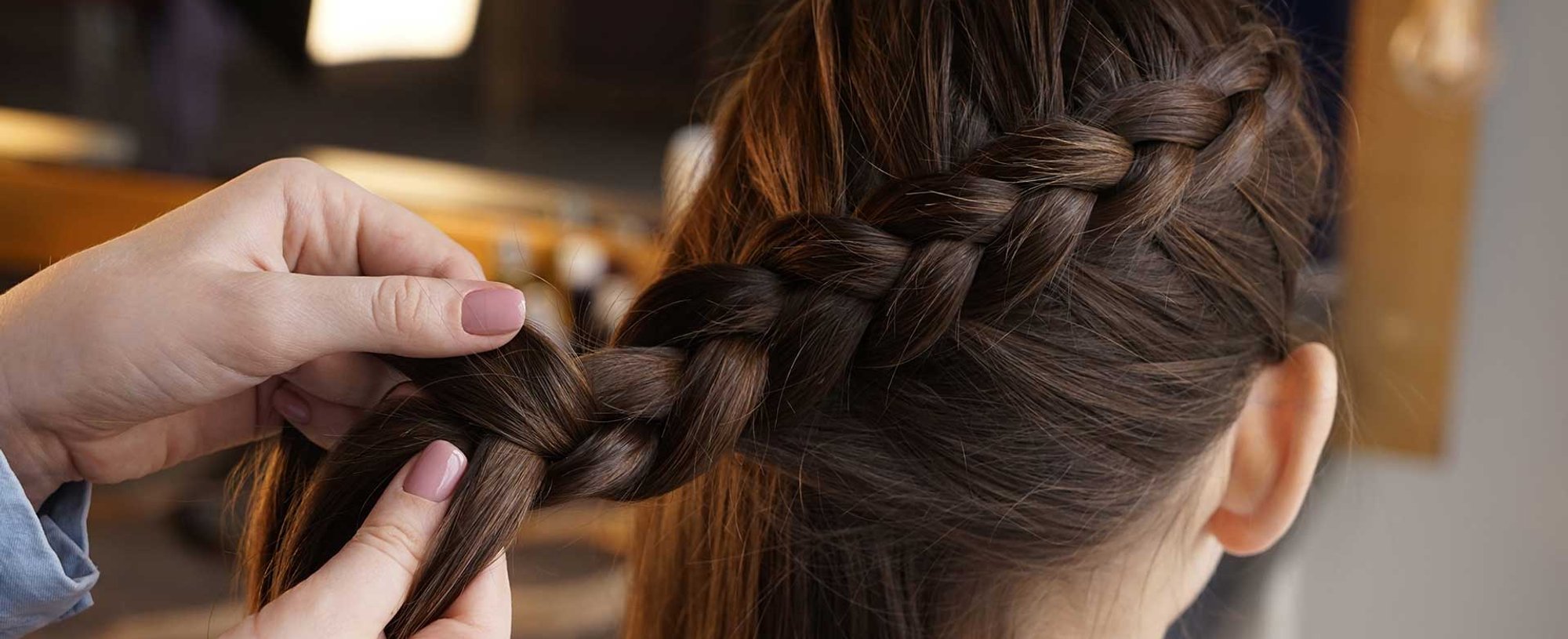 Profissional fazendo tranca em cabelo castanho escuro