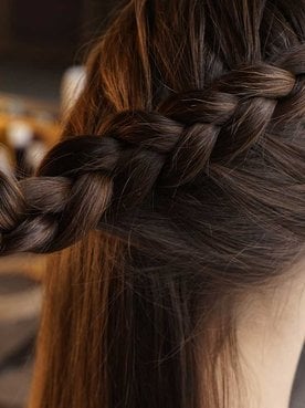 Profissional fazendo tranca em cabelo castanho escuro