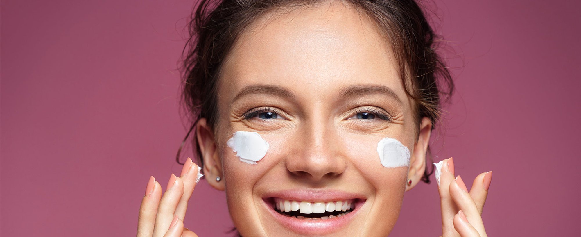 Modelo Sorrindo Passando Produto Em Seu Rosto