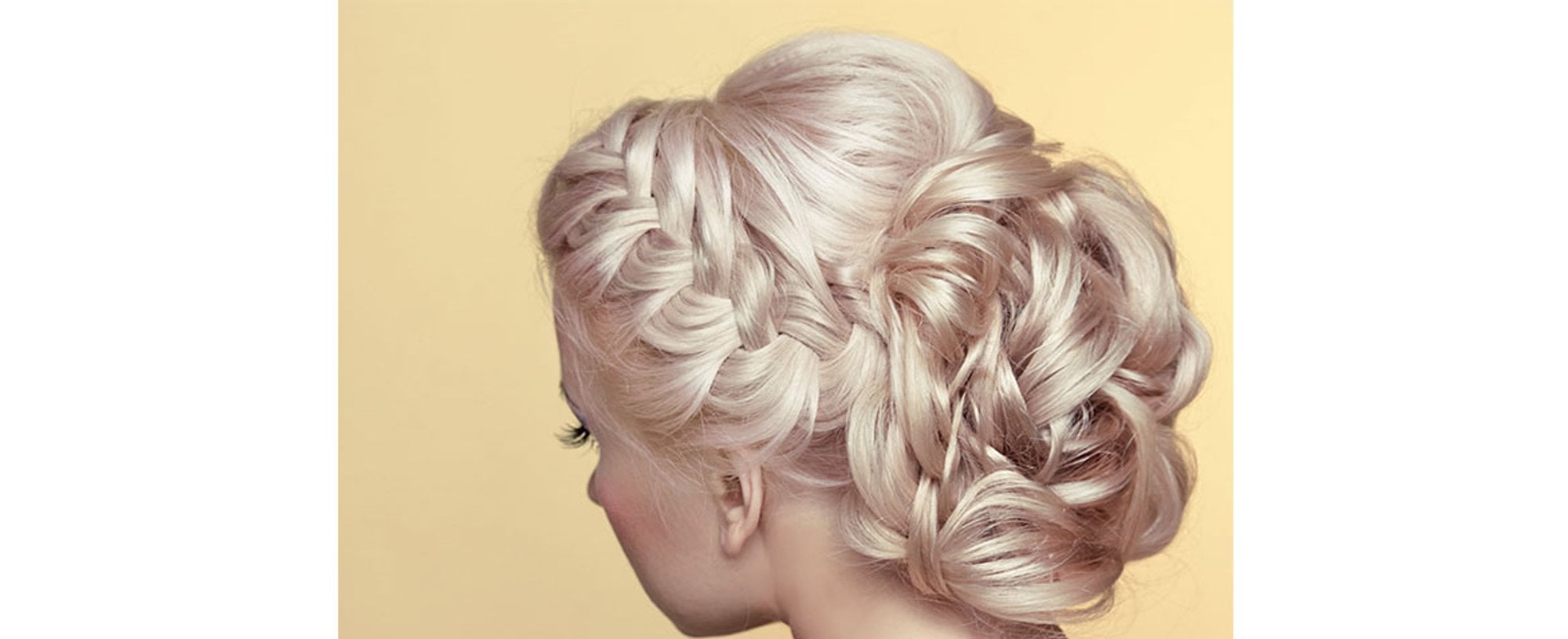 Modelo com cabelo loiro e coque trancado