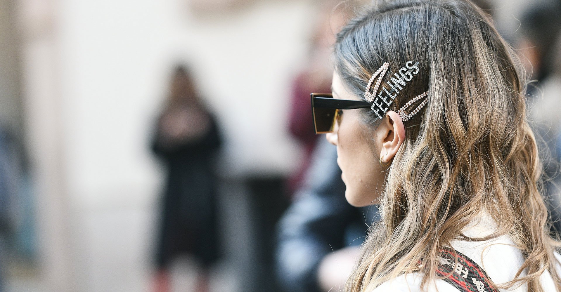 Mulher com presilha escrito feelings no cabelo com luzes