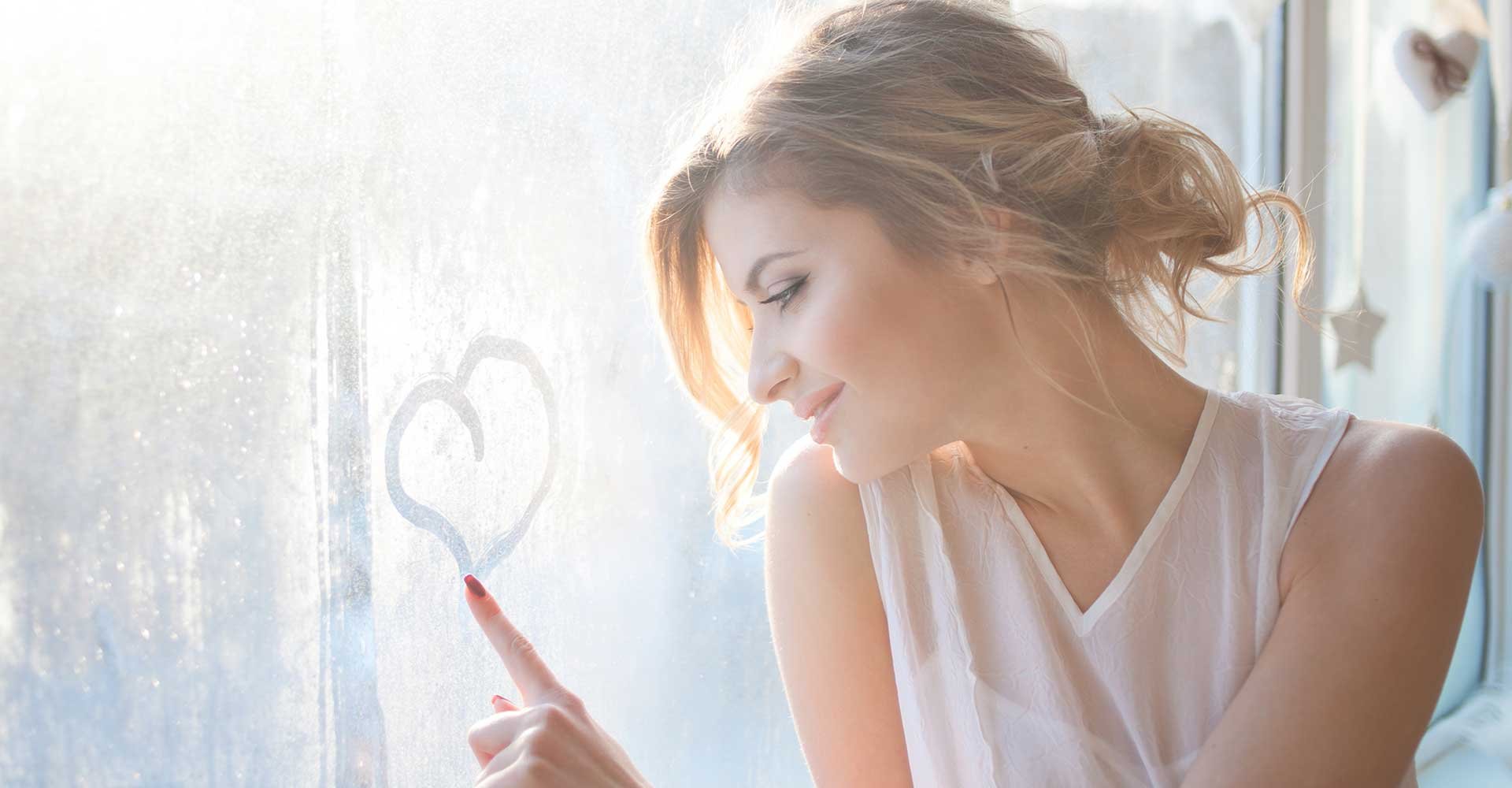 Mulher Loira Com Um Coque Fazendo Coracao Na Janela