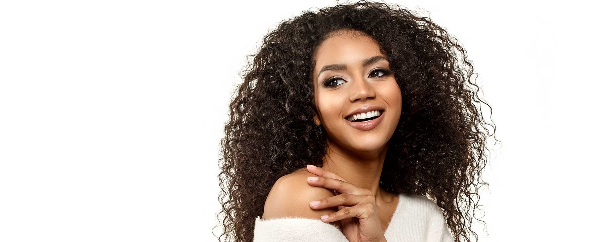 Modelo morena com cabelos cacheados e volumosos