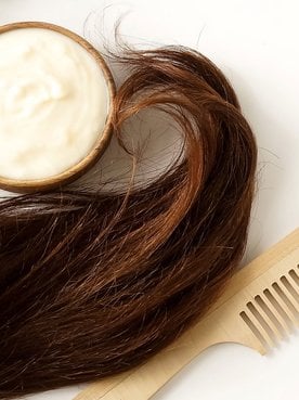 Imagem Mostrando Ponta De Um Cabelo Com Uma Escova E Um Produto Creme Ao Lado