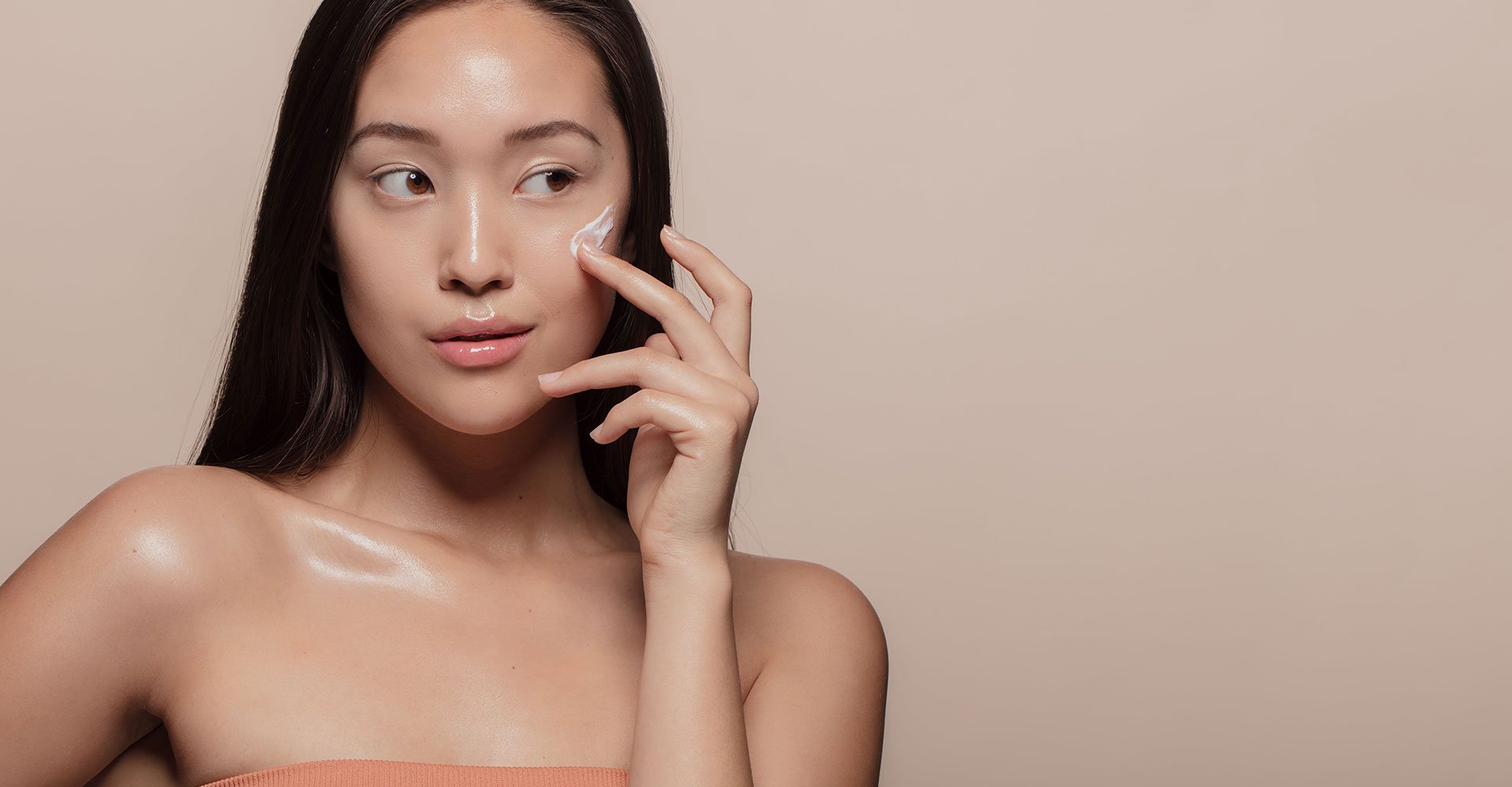 Modelo Asiatica Passando Produto Com Textura De Creme Cor Branca No Rosto