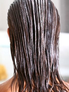 Mulher De Costas Com Produto Em Seu Cabelo