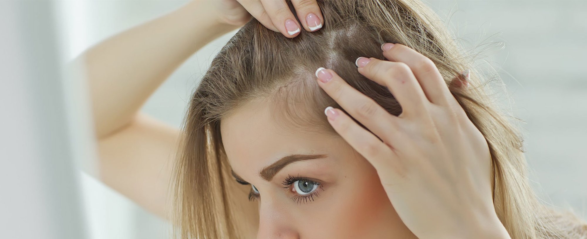 Mulher observando seu cabelo loiro no espelho