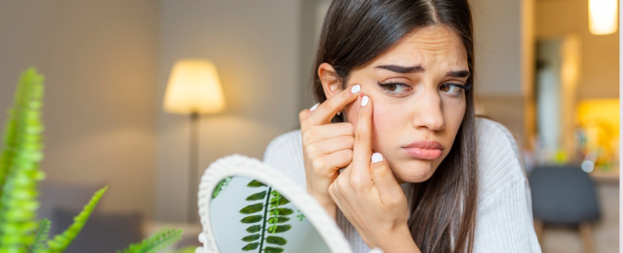 Modelo se olhando no espelho analisando acne