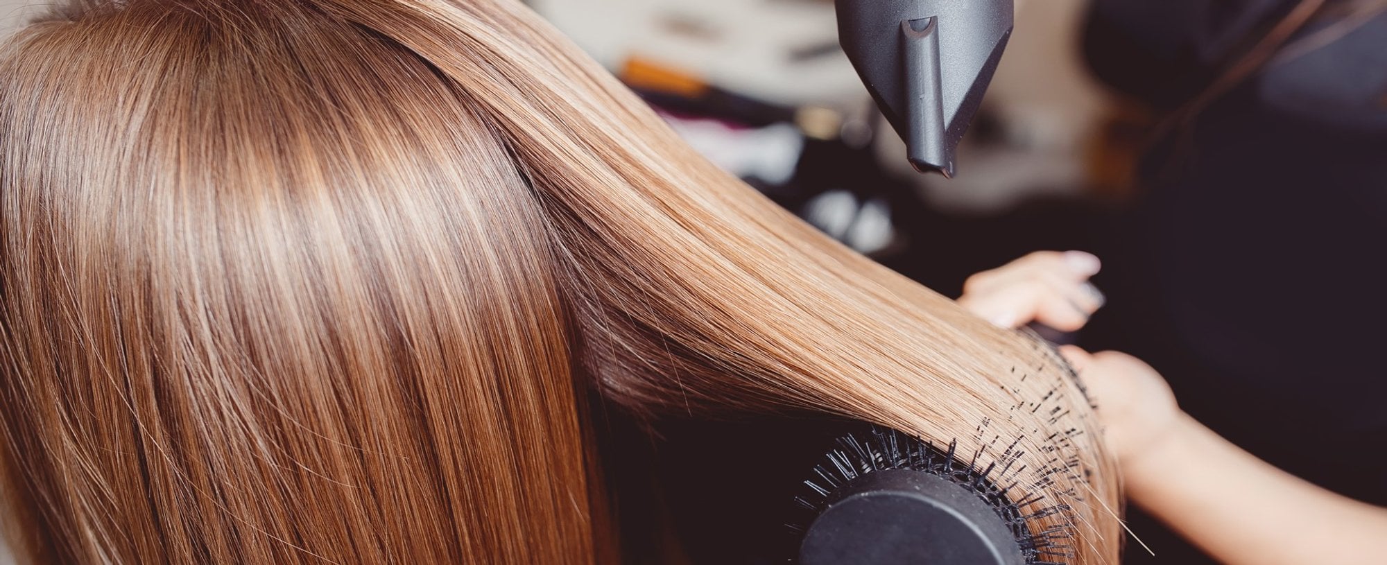 Profissional fazendo escova em cabelo loiro