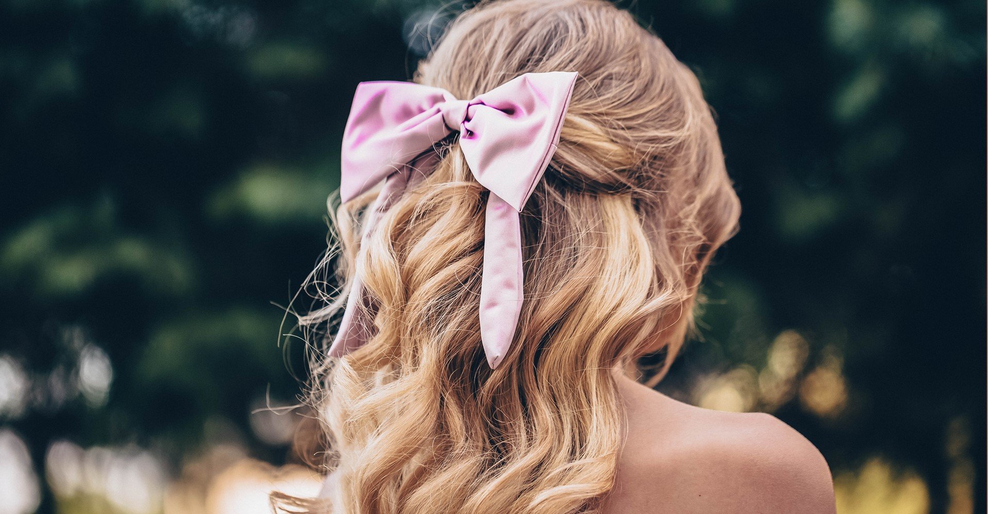 Modelo de costas com laço em seu cabelo loiro