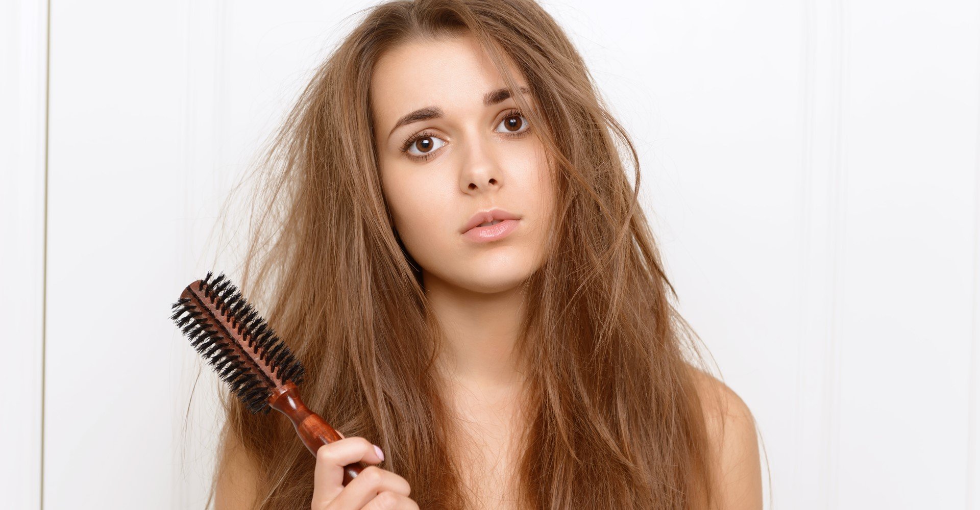 Modelo branca com cabelo bagunçado e escova na mão