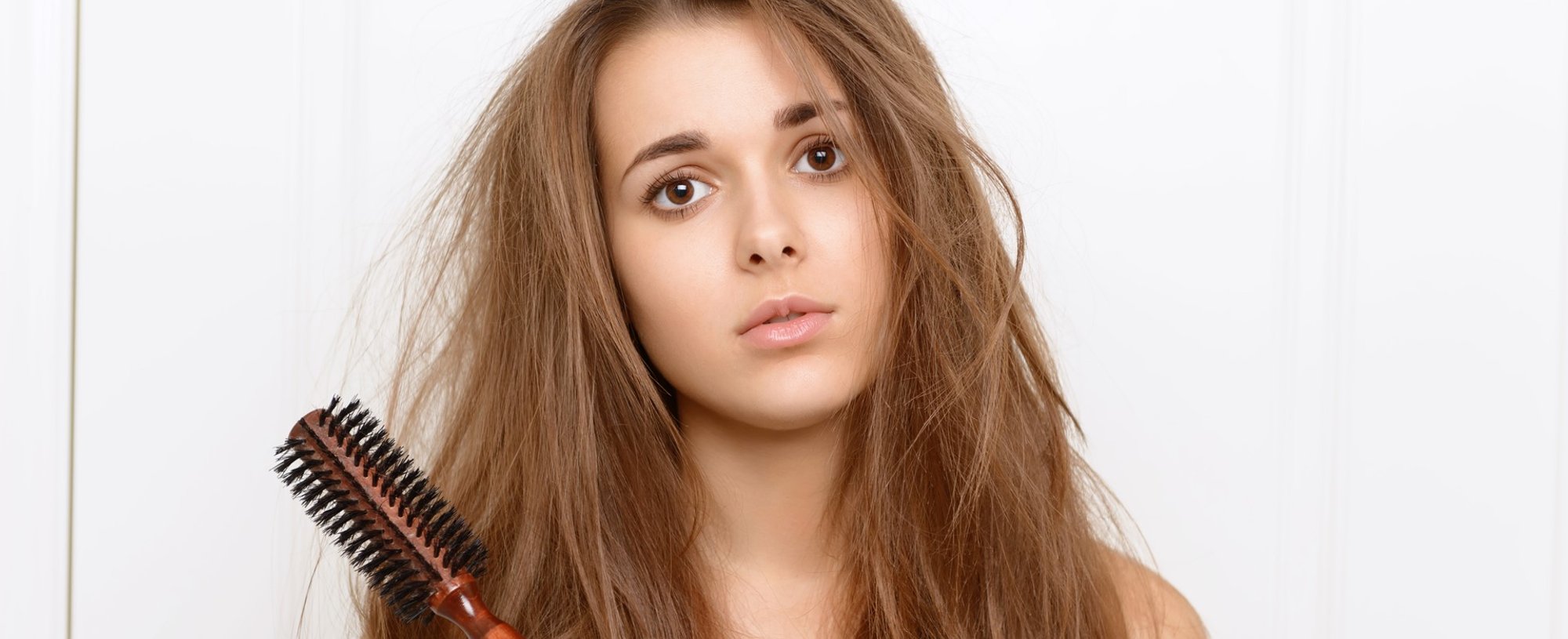 Modelo branca com cabelo bagunçado e escova na mão