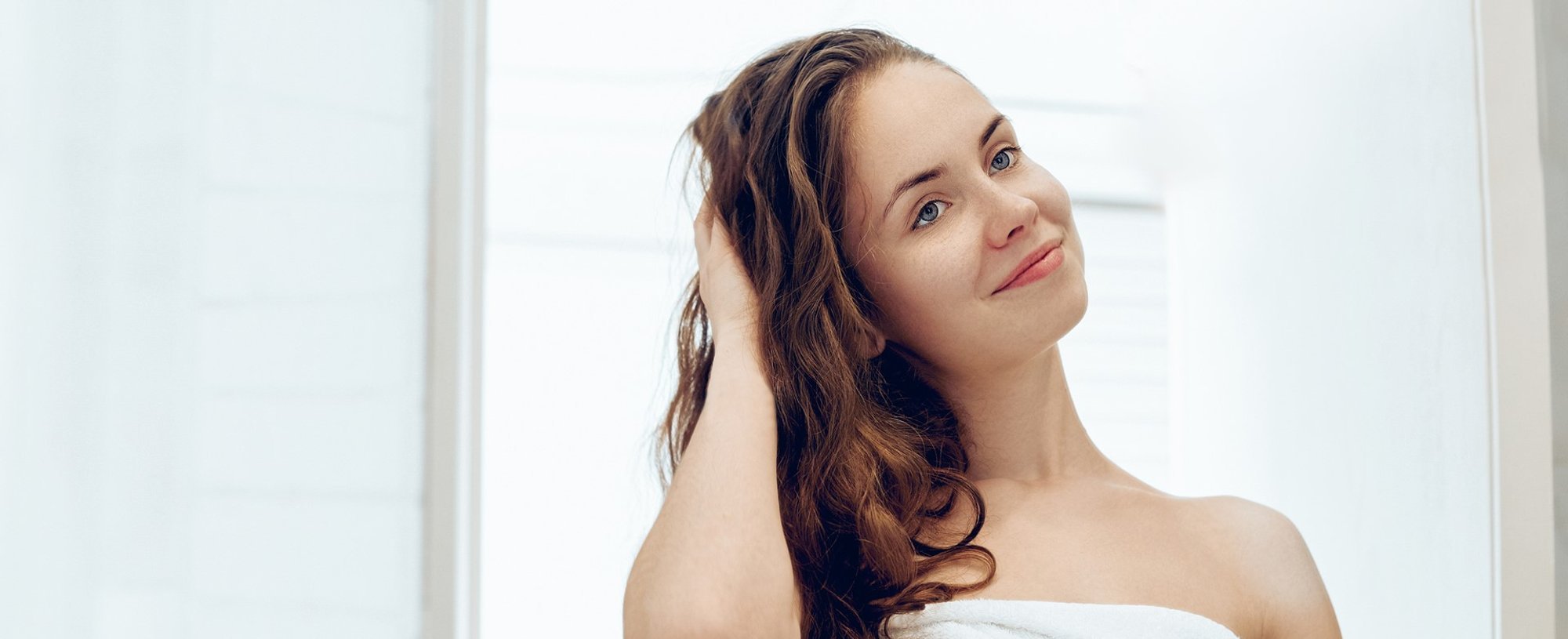 Modelo branca com a mão no cabelo