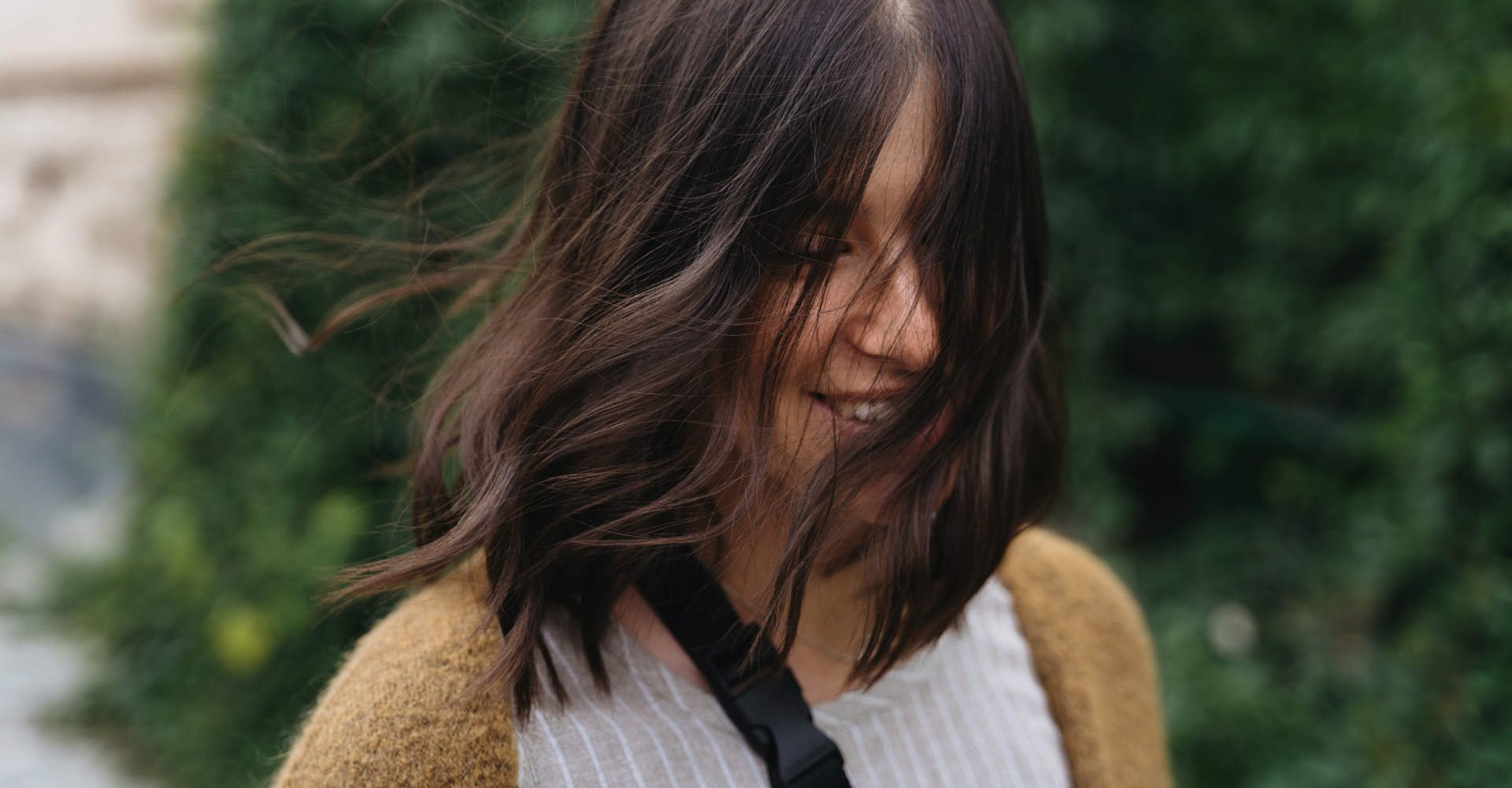 Modelo sorrindo com cabelos ao vento