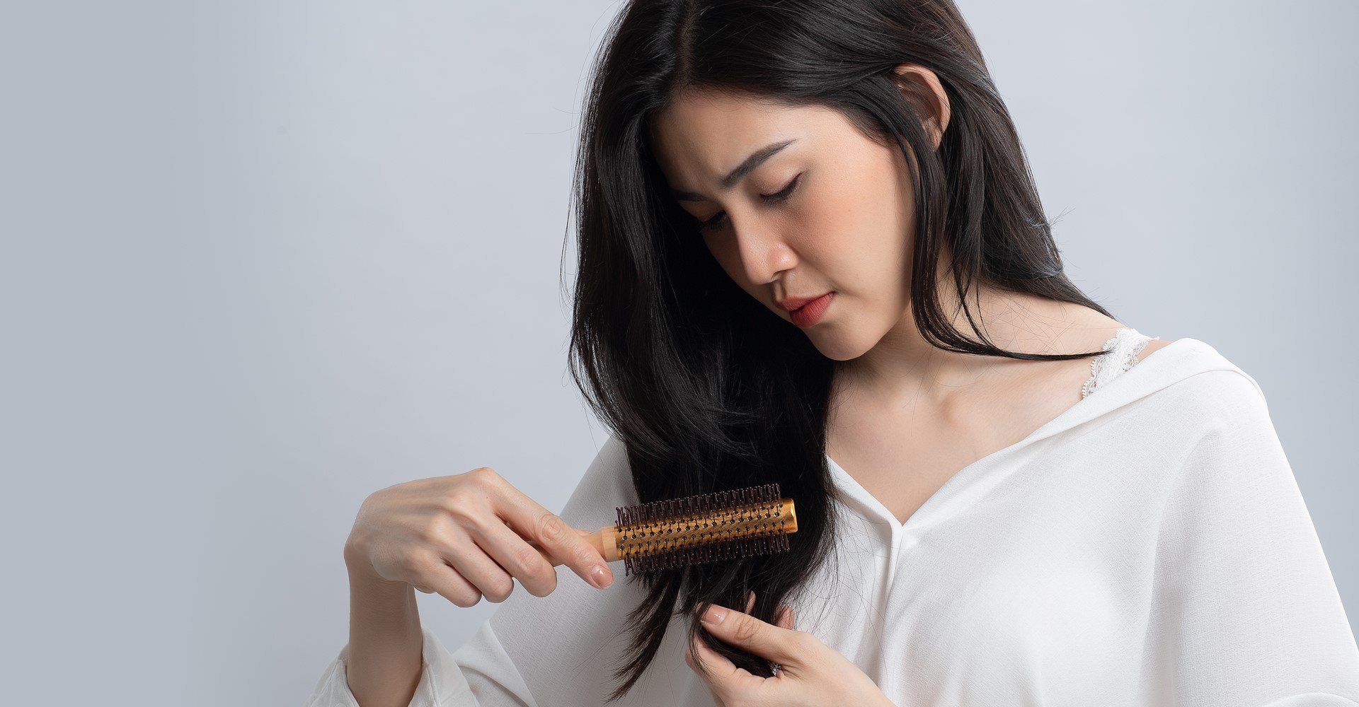 Modelo branca passando escova no cabelo