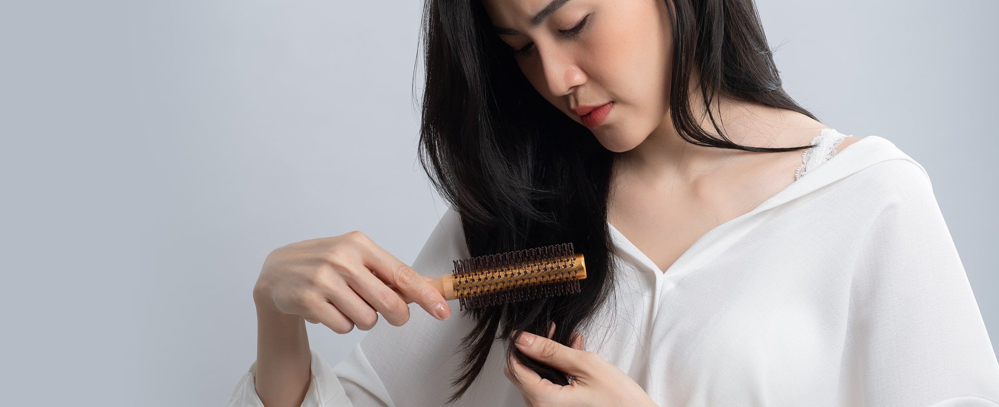 Modelo branca passando escova no cabelo