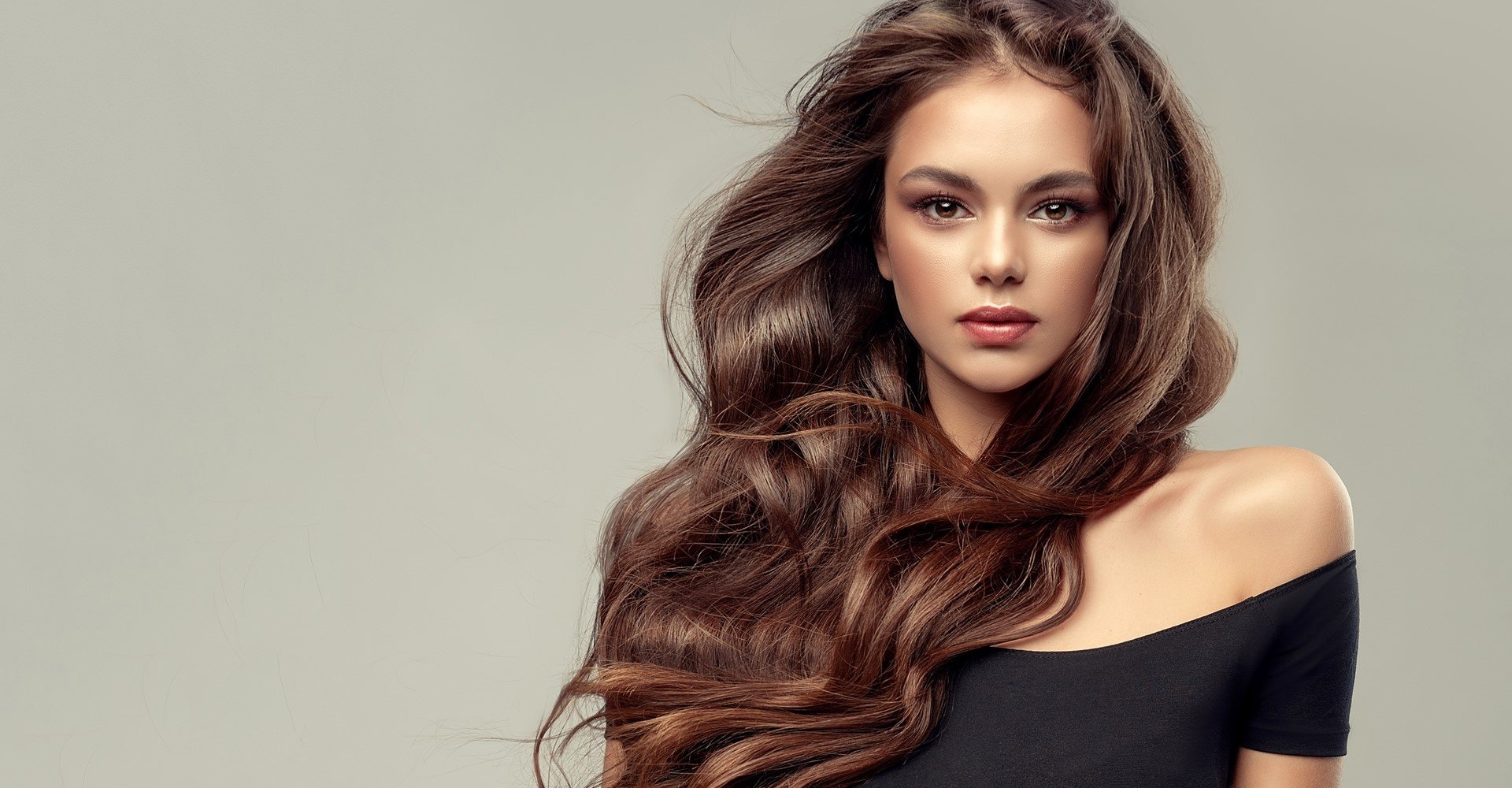 Modelo branca com cabelos castanhos longos e ondulados